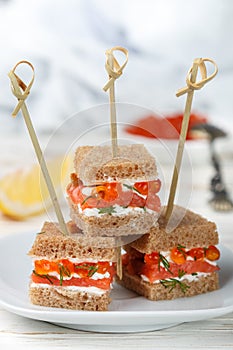 Rye bread Canapes with smoked salmon, soft cheese, dill and caviar