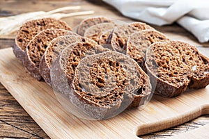 Rye bread with cereals, a fresh loaf of grain baguette on a wooden background