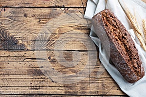 Rye bread with cereals, a fresh loaf of grain baguette on a wooden background. copy space
