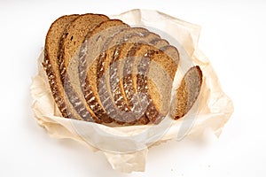 Rye bread cut in pieces lying on the baking paper on a white background