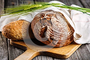 Rye bread with grains on wooden breadboard, food background, freshly baked traditional bread