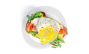 Rye bread sandwich with guacamole, arugula, tomatoes and quail egg isolated on a white background. Bruschetta with