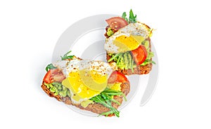 Rye bread sandwich with guacamole, arugula, tomatoes and quail egg isolated on a white background. Bruschetta with