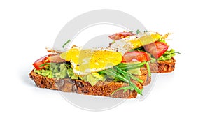 Rye bread sandwich with guacamole, arugula, tomatoes and quail egg isolated on a white background. Bruschetta with