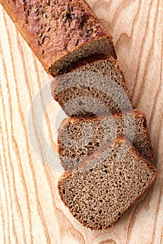 Rye bread with seeds. Sliced on wooden background