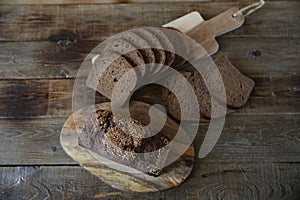 Rye bread with sesame seeds and rye sliced â€‹â€‹bread on a wooden rustic background, flat lay, with copy space for text, top view