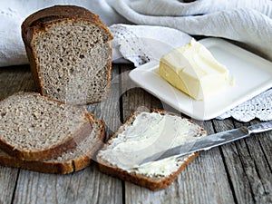 Rye bread and some butter to spread on the slices. Close up. Horizontal, rustic