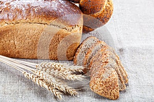 Rye bread, wheat loaf with poppy seeds and ears on sacking