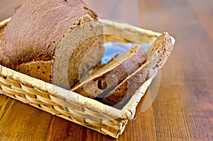 Rye homemade bread in a wicker basket on the board