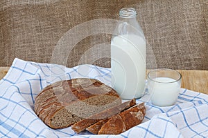 Rye sliced bread with bottle of milk on wooden table