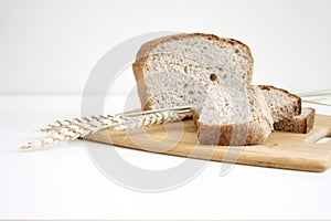 Rye and wheat bread. A loaf of bread on a cutting board with ears of wheat and a handful of wheat flour. Food