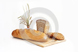 Rye-wheat bread, wheat loaf and consecrated cookies. Spikelets of wheat on the background