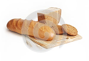 Rye-wheat bread, wheat loaf and consecrated cookies. Spikelets of wheat on the background