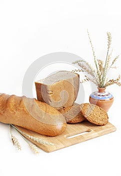 Rye-wheat bread, wheat loaf and consecrated cookies. Spikelets of wheat on the background