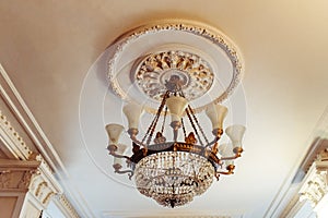 ÃÂ¡rystal chandelier shines hanging from the ceiling in the room. photo
