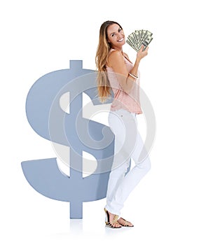 She's all about the Benjamins. Studio portrait of a woman standing in front of a large dollar sign and holding money.