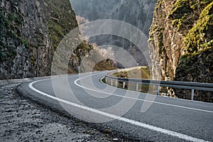 S curve, asphalt road bend between two huge stones