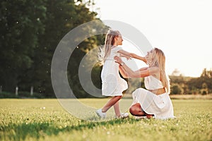 That`s so cute. Mother and daughter enjoying weekend together by walking outdoors in the field. Beautiful nature