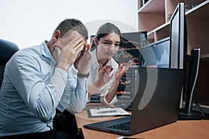 It`s failure. Team of stockbrokers are having a conversation in a office with multiple display screens