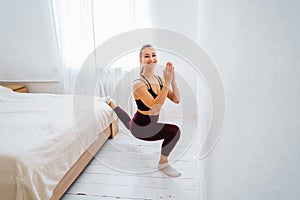 That`s how it should be. Flexible, muscular, athlete sportswoman does stretching, lifting leg up to the wall. Fitness trainer