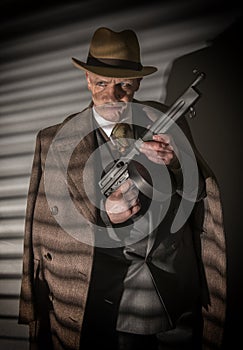 1940s male gangster holding a machine gun