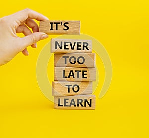 Its Never to Late to Learn symbol. Wooden blocks with words Its Never to Late to Learn. Beautiful yellow background. Businessm