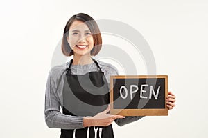 It`s open here. A smiling woman is holding a sign with the inscription.