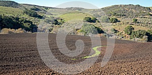 S shaped irrigation ditch in plowed field in Central California near Guadalupe California USA