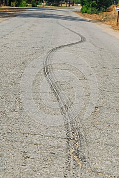 An S shaped tire rubber mark from a car on the asphalt.