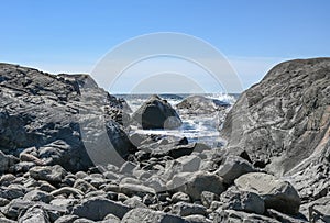 It\'s a sunny day on the coast of Vestfold, but the waves continue to crash over stone outcrops
