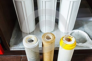 It`s time to change water filters at home. Replace filters in water purifying system. Close up view of three used filters.