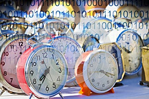 It`s time to protect your data - Concept image with old colored metal table clocks with binary code