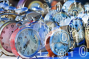 It`s time to protect your data - Concept image with old colored metal table clocks with binary code