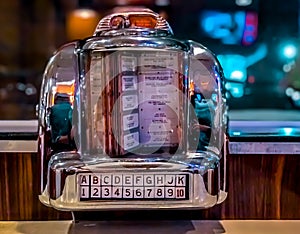 A 1960s vintage looking mini jukebox radio on a tabletop. photo
