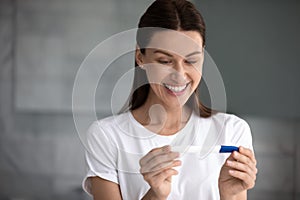 35s woman holding pregnancy test saw two stripes feels happy photo