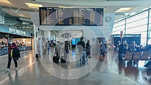 Sa Carneiro airport interior view, departures and arrivals information board, people walking with suitcases and bags and staying