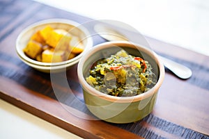 saag aloo paired with mango chutney in a small bowl