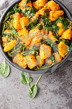 Saag aloo is a popular Indian and Pakistani side dish made by frying potatoes and leafy greens in spices and aromatics in a bowl
