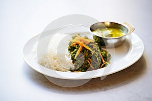 saag aloo served with basmati rice on a white plate