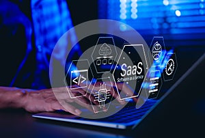 SaaS Software as a Service Concept. Man using laptop with futuristic interface SaaS Software as a Service icons, cloud computing