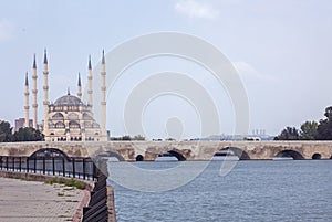 Sabanci Merkez Cami Central Mosque with Tash KÃ¶prÃ¼ Bridge on Seyhan River in cloudy weather in Turkey