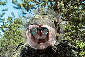 Saboteur or scout secretly watches through binoculars