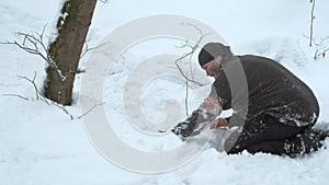 Saboteur soldier sets up tripwire bomb burying it under snow