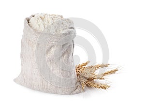 Sack with flour and wheat spikes on white background