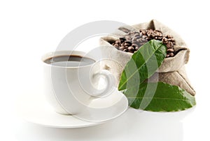 Sack full of coffee beans with green leaves and coffee cup