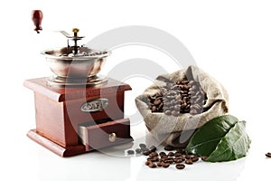 Sack full of coffee beans with green leaves with mill