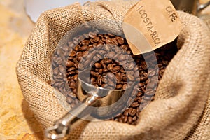 Sack of roasted coffee beans with metal scoop