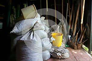 Sacks with Fertilizers and Agricultural Tools in Garden Shed