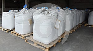 Sacks of flour and grain are stacked in neat rows in the warehouse of the processing factory.