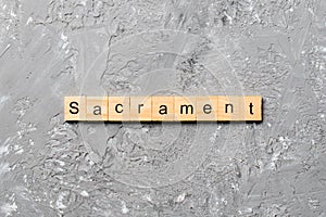 Sacrament word written on wood block. sacrament text on table, concept